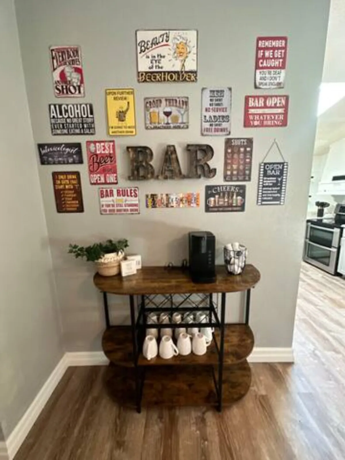 A cheerful interior scene featuring a wooden bar cart with bar signage, a coffee maker, and white mugs, evoking a welcoming space for socializing and enjoying drinks. The cozy layout and inviting decor encourage togetherness and relaxation.